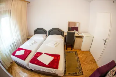 a large bed in a room with a desk at Guesthouse Blue Coast in Budva