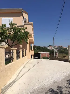 a house with a driveway in front of a building at Ceka Apartments in Ulcinj