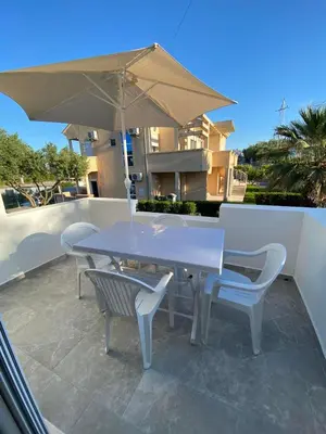 a white table and chairs with an umbrella on a patio at Ceka Apartments in Ulcinj