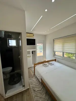 a bedroom with a bed and a toilet and a window at Ceka Apartments in Ulcinj