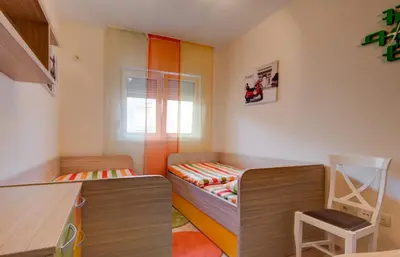 a small room with a bed and a chair at Piano Apartments Delta City in Podgorica