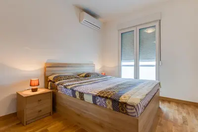 a bedroom with a bed and a window at Piano Apartments Delta City in Podgorica