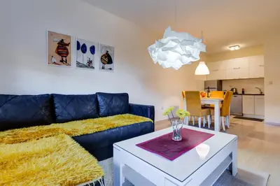 a living room with a couch and a table at Piano Apartments Delta City in Podgorica