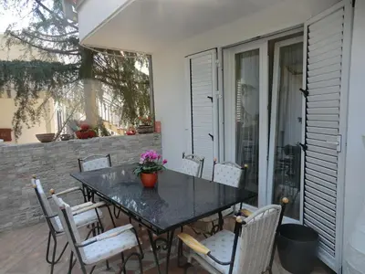 a dining table and chairs on a patio at Holiday Home Hermes in Budva
