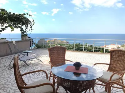 a patio with a table and chairs and the ocean at Apartment Jana in Ulcinj