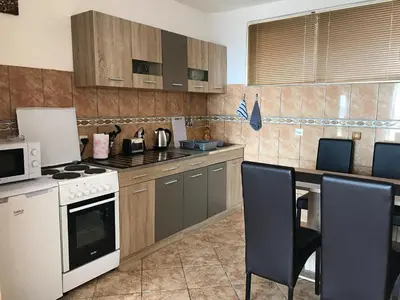 a kitchen with a stove and a table with chairs at Apartment Jana in Ulcinj