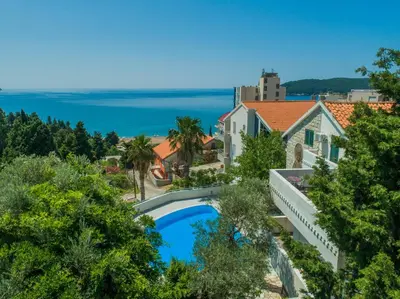an aerial view of a house with a swimming pool and the ocean at The Turtles Garden in Becici