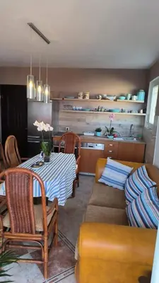 a living room with a table and chairs and a kitchen at Apartment Dmitr Petrovac in Petrovac na Moru