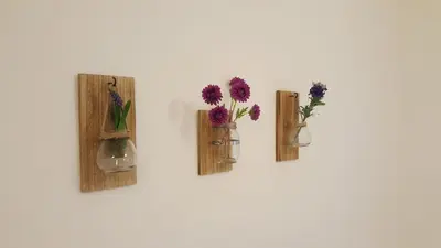 three vases with flowers in them on a wall at Summer apartment in Bar