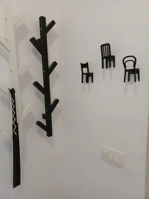 a group of black chairs on a white wall at Summer apartment in Bar
