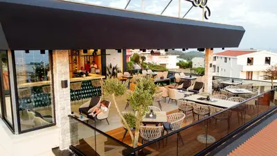 a balcony of a restaurant with tables and chairs at Hotel Princess & Spa in Ulcinj