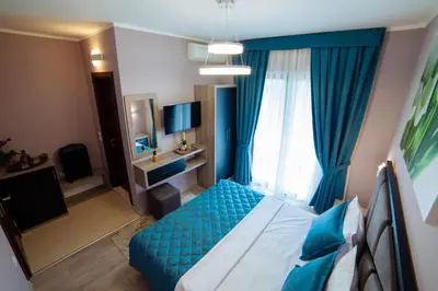 a bedroom with a blue bed and a window at Hotel Princess & Spa in Ulcinj