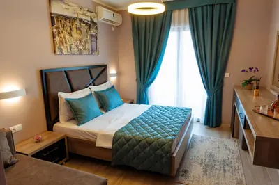 a bedroom with a bed with blue pillows at Hotel Princess & Spa in Ulcinj