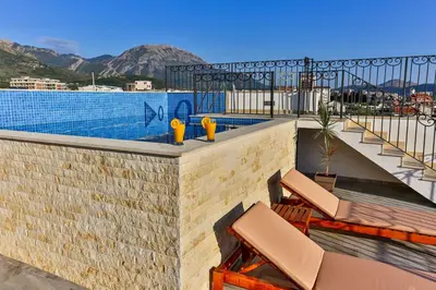 a balcony with chairs and a swimming pool at De Lux Apartments Luka in Bar