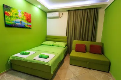a green room with two beds and a couch at De Lux Apartments Luka in Bar