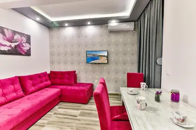 a living room with a red couch and a table at De Lux Apartments Luka in Bar