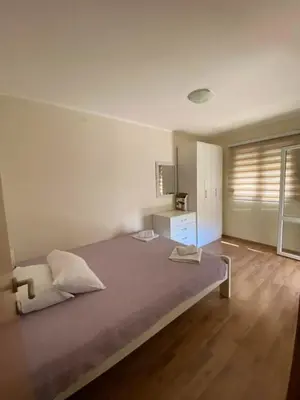 a bedroom with a large bed and a wooden floor at Apartments Luna in Bar