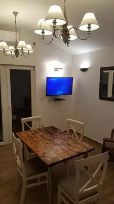 a dining room with a wooden table and a tv at Garden apartmant near sea in Kotor
