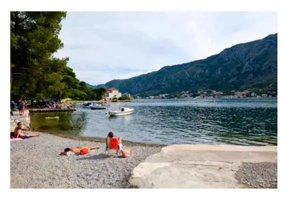 a group of people on a beach near a body of water at Garden apartmant near sea in Kotor