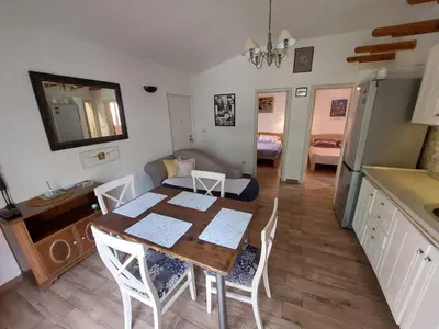 a kitchen and dining room with a table and chairs at Garden apartmant near sea in Kotor