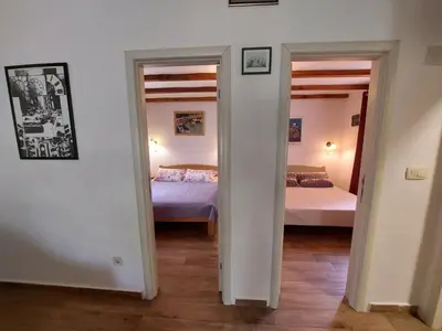 a room with two beds and two open doors at Garden apartmant near sea in Kotor