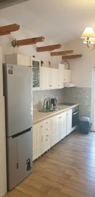 a kitchen with white cabinets and a refrigerator at Garden apartmant near sea in Kotor