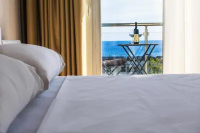 a bedroom with a bed and a view of the ocean at Luna Apartmani in Sutomore