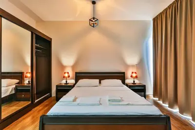 a bedroom with a bed and two lamps on two tables at Luna Apartmani in Sutomore
