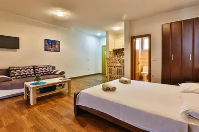 a bedroom with a large bed and a couch at Luna Apartmani in Sutomore