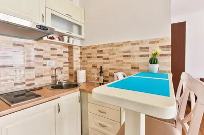 a kitchen with a sink and a counter top at Luna Apartmani in Sutomore