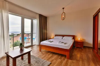 a bedroom with a bed and a large window at Luna Apartmani in Sutomore