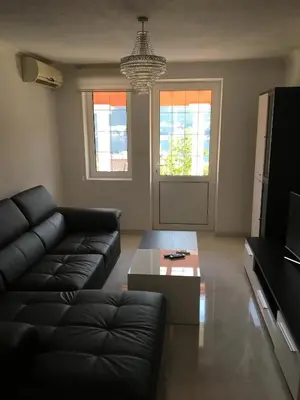 a living room with a black couch and a coffee table at Apartment Apollo in Kotor