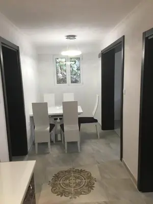 a dining room with a table and white chairs at Apartment Apollo in Kotor