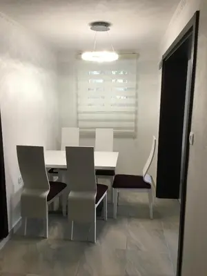 a dining room with a white table and chairs at Apartment Apollo in Kotor