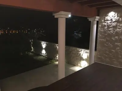 a porch with two white columns at night at Apartment Apollo in Kotor