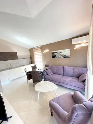 a living room with a purple couch and a table at Apartments Harris in Ulcinj
