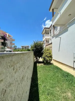 a retaining wall in a yard next to a building at Apartments Harris in Ulcinj