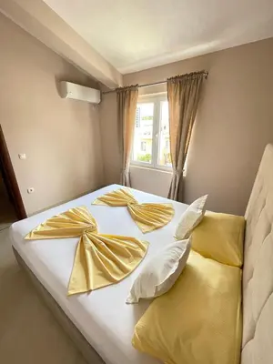 a bed with gold sheets and pillows with a window at Apartments Harris in Ulcinj