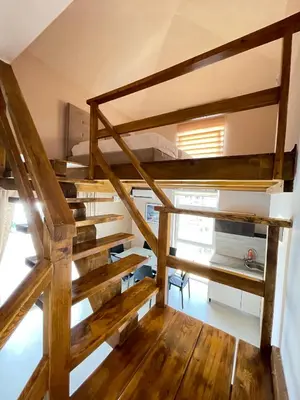 a room with two bunk beds and wooden stairs at Apartments Harris in Ulcinj