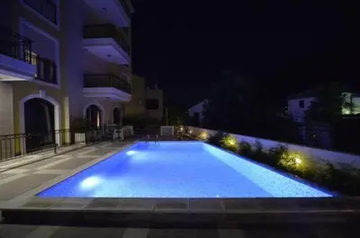a large swimming pool at night with a building at Apartments Posto Capitano 0202 in Kotor