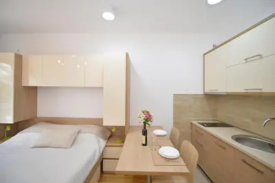 a small kitchen with a bed and a sink at Apartments Posto Capitano 0202 in Kotor