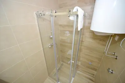 a shower with a glass door in a bathroom at Apartments Posto Capitano 0202 in Kotor