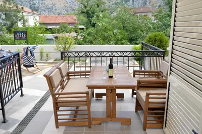a patio with a wooden table and chairs on a balcony at Apartments Posto Capitano 0202 in Kotor