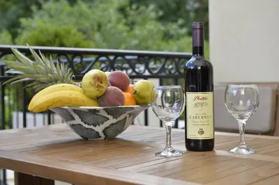 a bowl of fruit with a bottle of wine and two glasses at Apartments Posto Capitano 0202 in Kotor