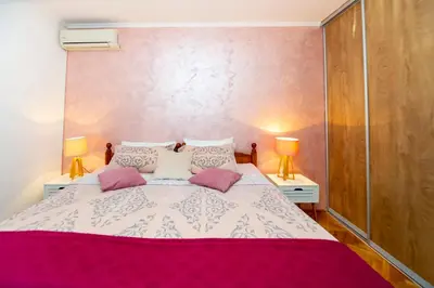 a bedroom with a large bed with two lamps at Apartment Stanko in Pržno