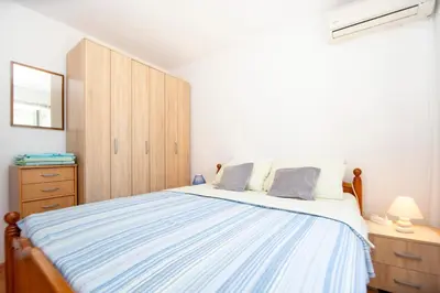 a bedroom with a large bed and a wooden cabinet at Apartment Stanko in Pržno