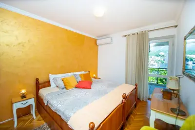 a bedroom with a bed with yellow walls and a window at Apartment Stanko in Pržno
