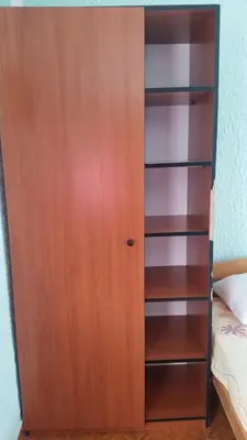 a wooden book shelf next to a bed at Guesthouse Ada in Bar