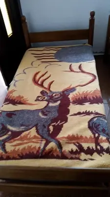 a bed with a painting of two people on it at Apartment Oaza in Bar