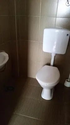 a bathroom with a white toilet and a sink at Apartment Oaza in Bar